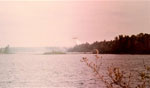 If you look very closely perhaps you can see the plane dropping water just above the tree line.  Fire on island campsite in LLC, 1980.